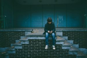 boy-with-smartphone-on-empty-old-dark-stage-gaelle-marcel-unsplash