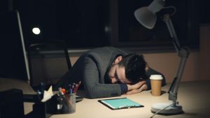 man-sleeping-at-desk-with-coffee-and-tablet-vitaly-gariev-unsplash