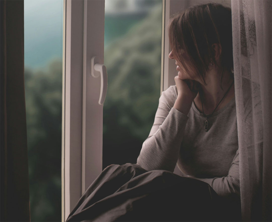 woman-sits-by-the-window-gazing-out-by-ruslan-sikunov-at-unsplash