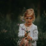 young-girl-holding-flowers-by-janko-ferlic-at-unsplash
