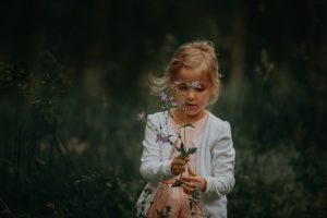 young-girl-holding-flowers-by-janko-ferlic-at-unsplash