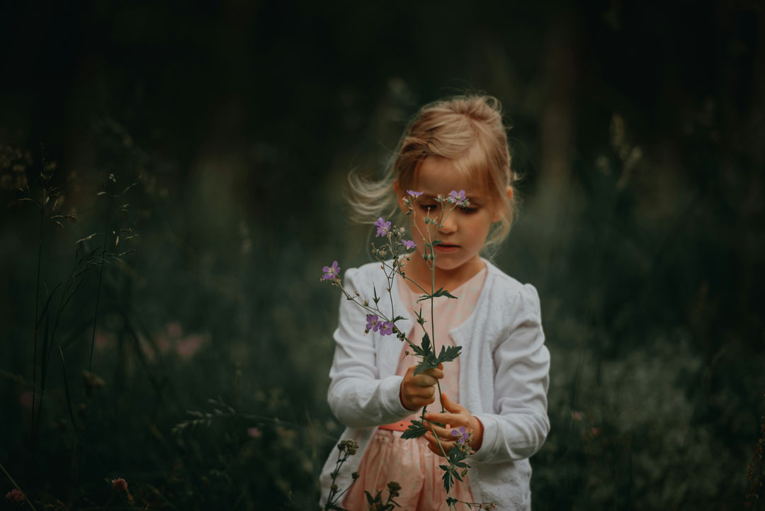 young-girl-holding-flowers-by-janko-ferlic-at-unsplash