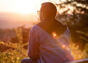 man-sitting-watching-sunset-mitchell-hartley-unsplash