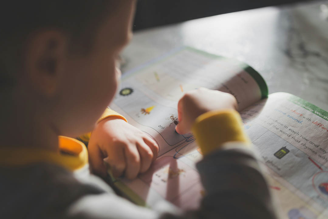 kid-answering-book-after-school-stephen-andrews-unsplash